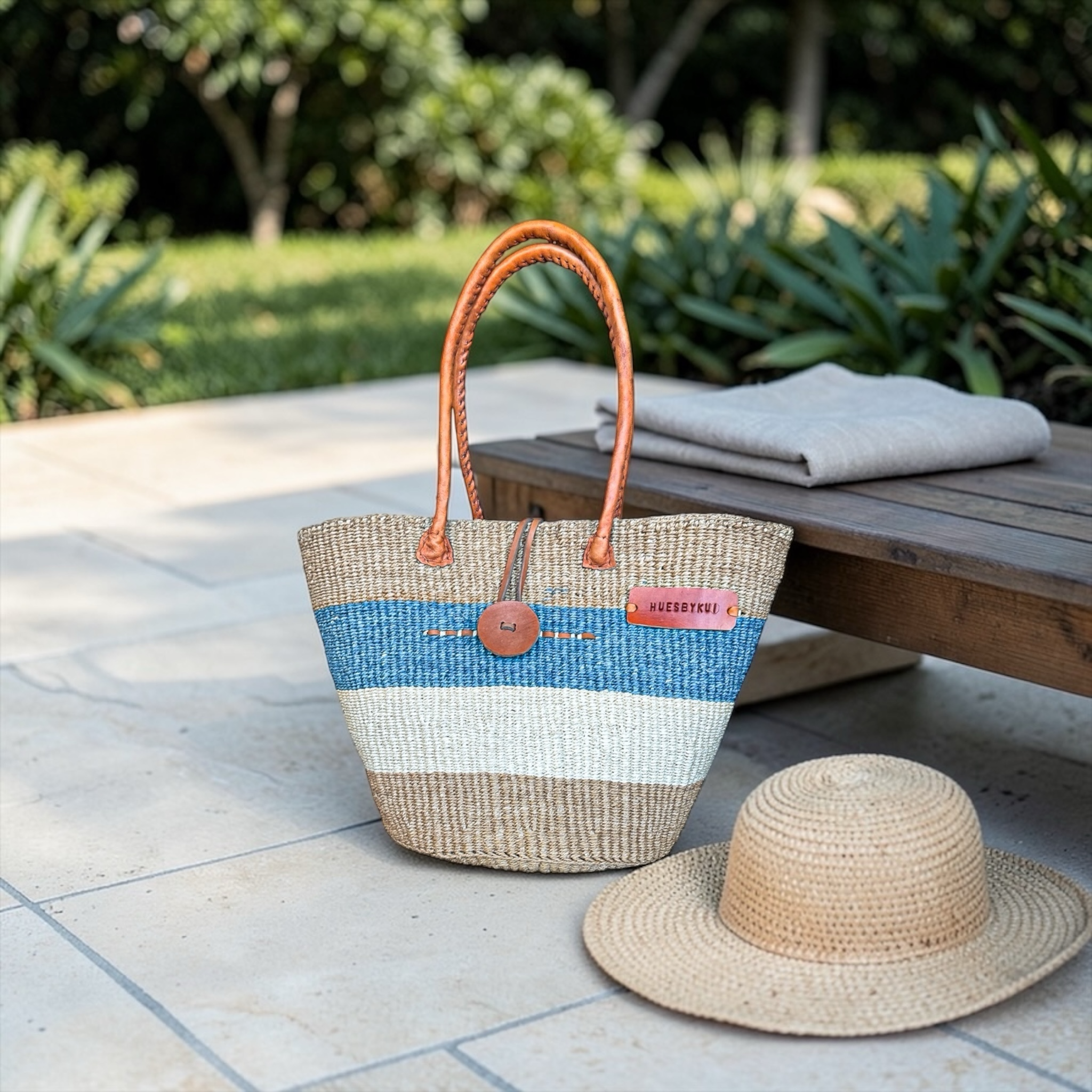 
Pwani Signature Sisal Basket styled on resort terrace with straw hat showcasing coastal lifestyle look