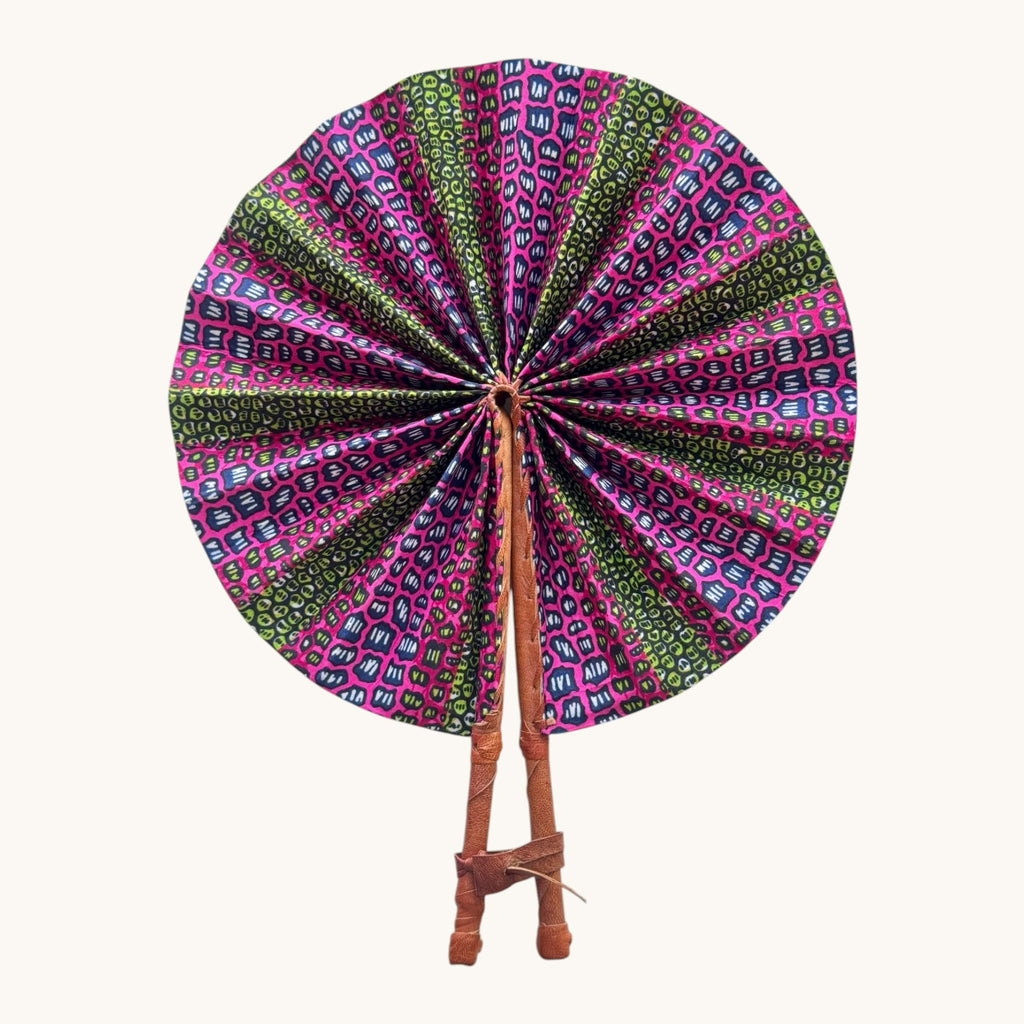 Hues by Kui handcrafted folding fan with vibrant pink, green, and blue geometric fabric and leather-wrapped handle.