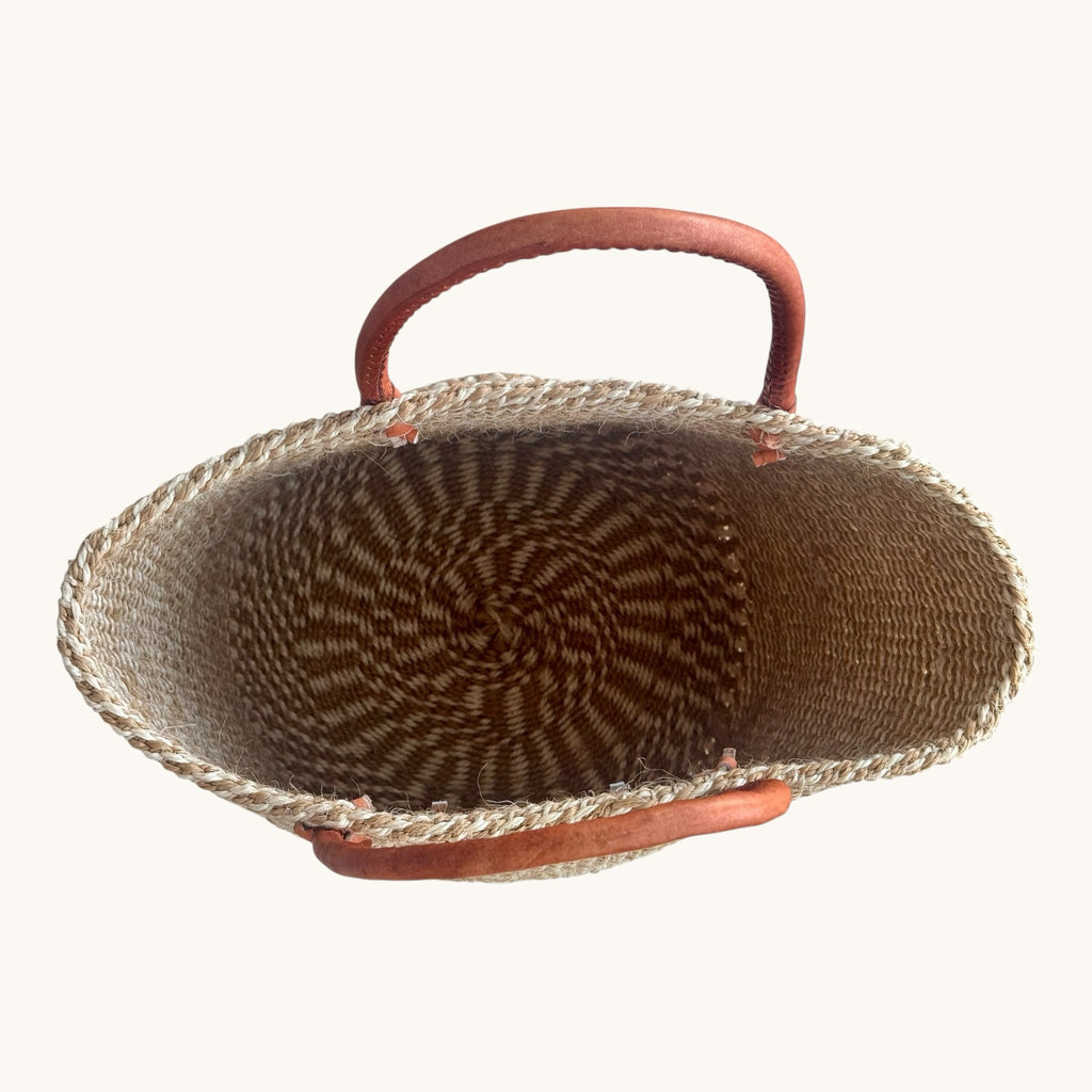 Hues by Kui handwoven natural fibre tote bag with rich brown leather handles, top-down view.