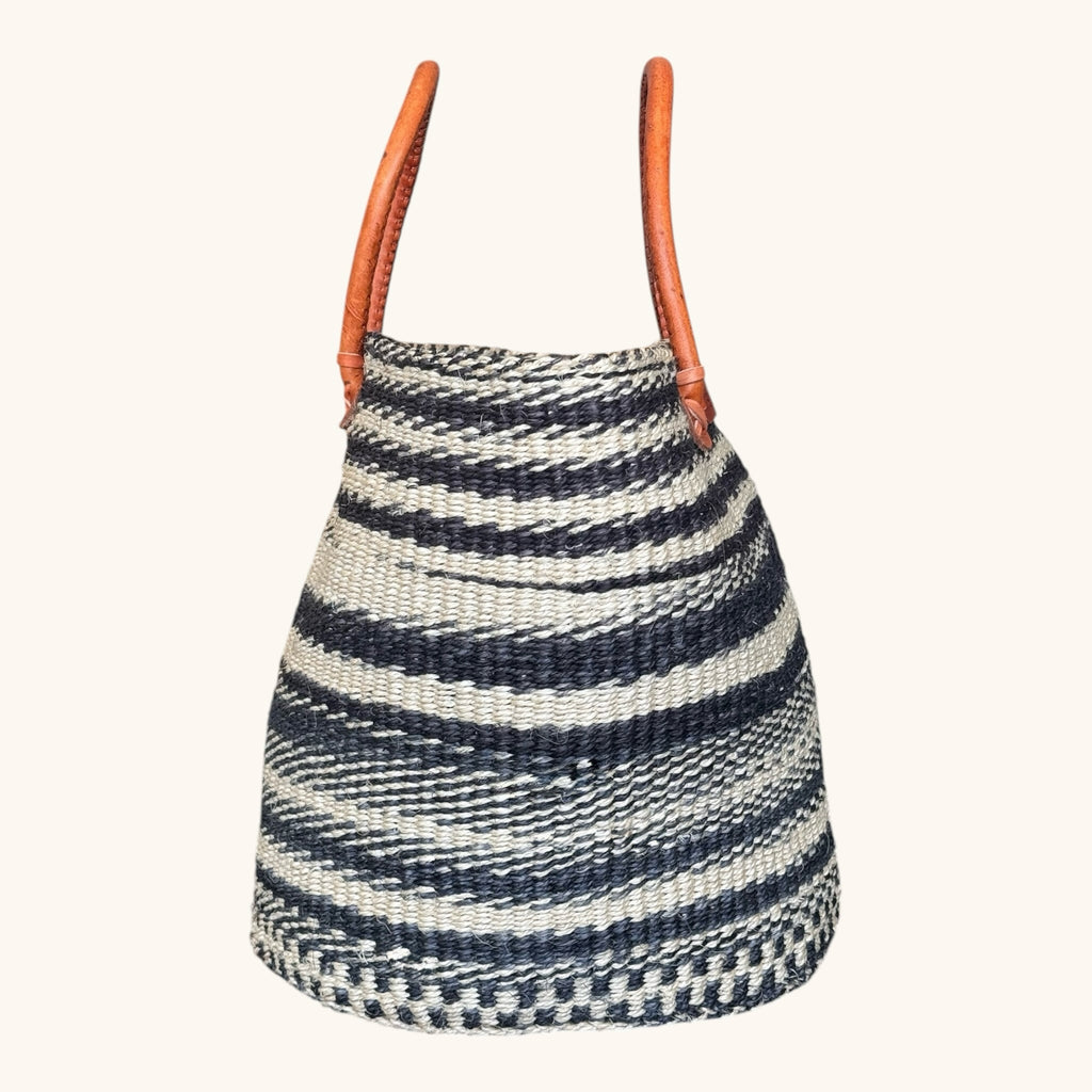 Hues by Kui handwoven straw tote bag with monochrome stripes and tan leather handles for a chic artisanal look.
