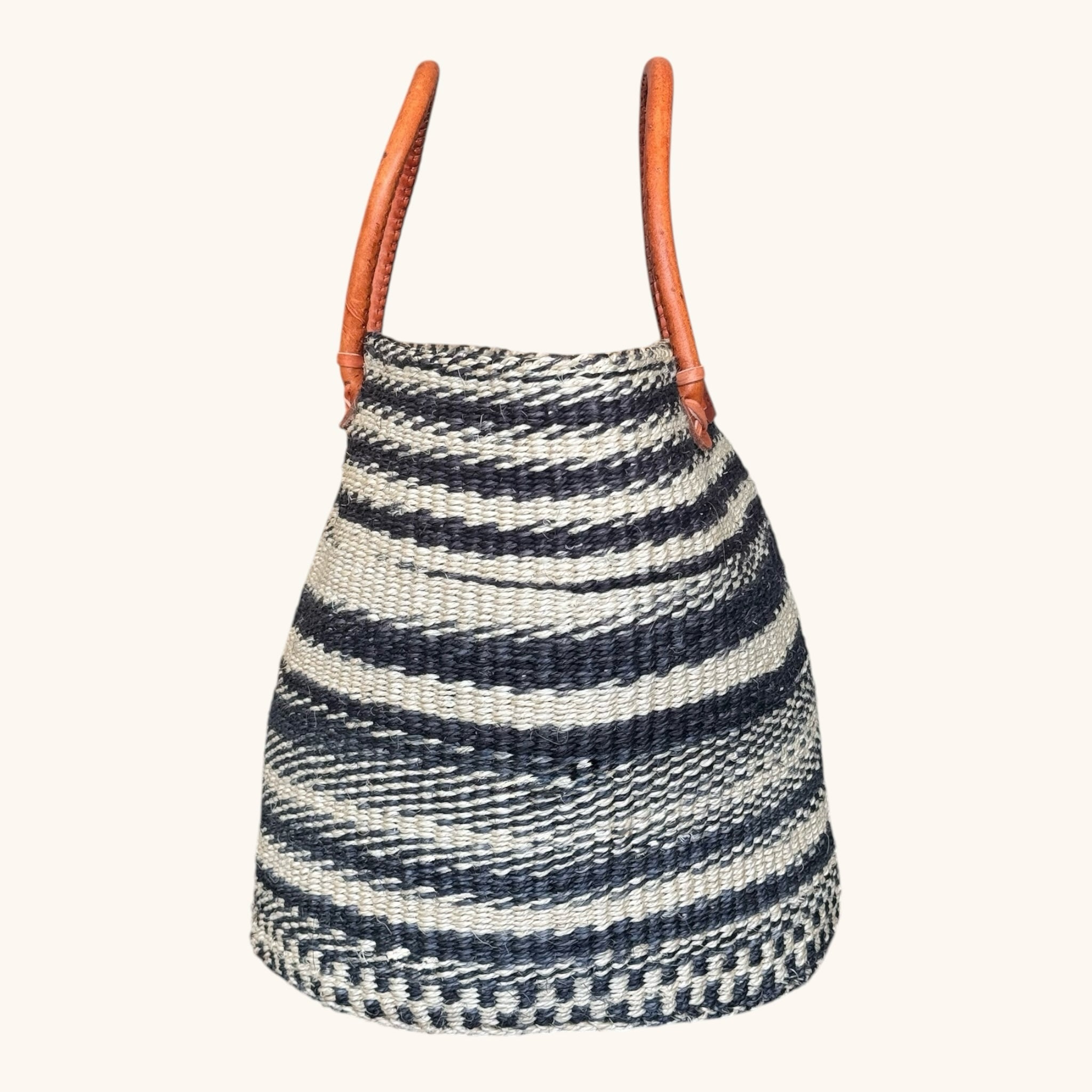 Hues by Kui handwoven straw tote bag with monochrome stripes and tan leather handles for a chic artisanal look.