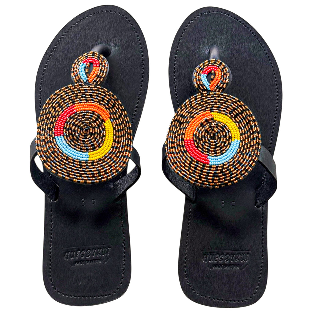 Nuru handmade black leather sandals with bold circular beaded design by Hues by Kui
